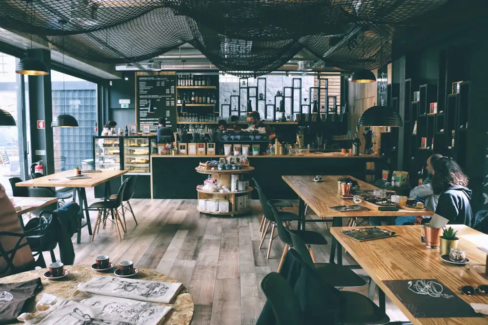 A warmly lit cafe interior seen through the window